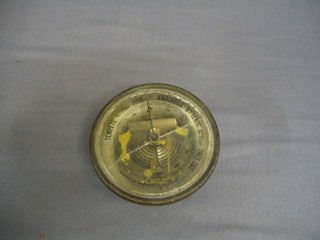 A circular aneroid barometer contained in a metal case (glass f)