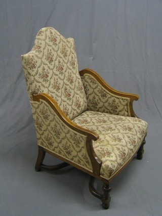 An Edwardian inlaid mahogany show frame arm chair with arch shaped back, raised on turned and block supports