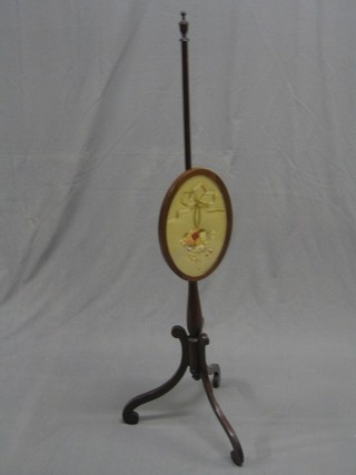 A Victorian mahogany pole screen with oval runner, raised on pillar and tripod supports