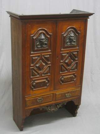 A Victorian carved walnut cabinet fitted a cupboard enclosed by a panelled door, the base fitted 2 drawers 31" (formerly part of a wardrobe)