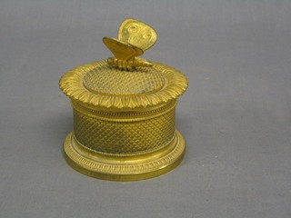 A 19th Century Continental gilt metal ink well of cylindrical form, the interior fitted porcelain inkwell and sander, the lid finial in the form of a butterfly 4"