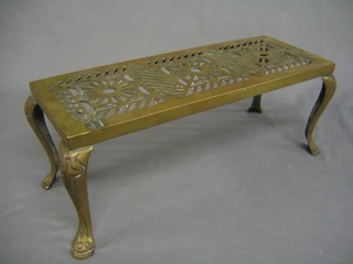A rectangular pierced brass trivet raised on cabriole supports 16"