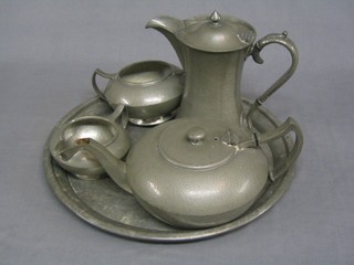 An Art Deco Dixons Cornish planished pewter 4 piece tea service with teapot, waisted hotwater jug, cream jug and sugar bowl, together with a similar tray