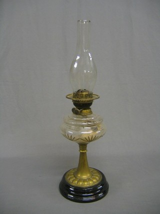 A cut glass oil lamp reservoir raised on a brass base