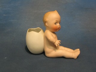 A 19th Century German biscuit porcelain spill vase in the form of a seated naked child supporting a cracked egg, the base impressed 9743 4"