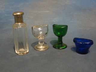 A faceted cut glass scent bottle with plated lid, 4", a blue glass eye bath, a green glass and a clear glass ditto,