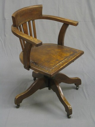 An Edwardian oak tub back revolving office chair