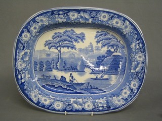 A 19th Century blue and white patterned meat plate decorated landscape with river 17"