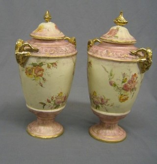 A pair of Edwardian pink glazed pottery  urns and covers with rams horn handles and floral decoration 16"