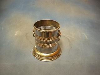 A circular pierced silver plated soda siphon holder