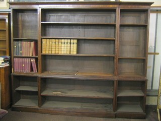 A Victorian rosewood break front triple bookcase, the upper section with moulded cornice fitted adjustable shelves, the base fitted adjustable shelves, raised on a platform base, 106" (requires some attention)