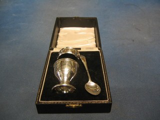 A silver egg cup, spoon and napkin, Birmingham 1921, cased