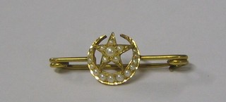 A Victorian gold bar brooch in the form of a star and crescent moon set demi-pearls