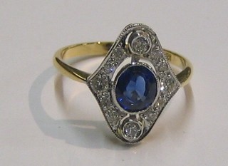 A lady's 18ct gold marquise shaped dress ring set large sapphire and 4 diamonds, supported by numerous other diamonds