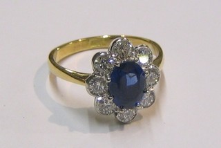 A lady's very attractive 18ct gold dress ring set an oval cut sapphire surrounded by 8 diamonds (0.95/1.56ct)