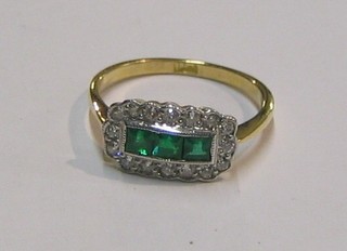 A lady's 18ct yellow gold dress ring set 3 square cut emeralds supported by diamonds