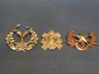 A Gordon Highlander's cap badge, a Highland Light Infantry cap badge and a Cameronian's cap badge