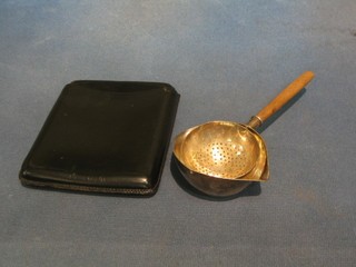 A Continental silver tea strainer and a leather cigar case