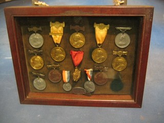 14 various Victorian and Edwardian School Board of London Attendance medals, contained a mahogany frame