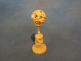 A carved ivory puzzle ball and stand
