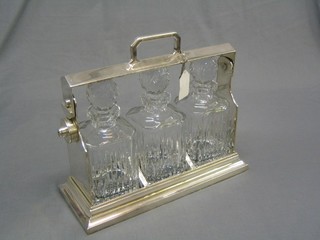 A 20th Century silver plated 3 bottle tantalus with 3 cut glass spirit decanters