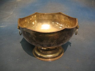 A circular silver bowl with wavy border and lion mask handles, raised on a circular spreading foot 10"