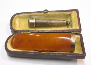 An amber and gold mounted cigar holder and a silver cigar holder