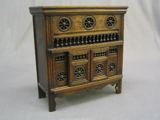 A 19th Century miniature cabinet in the form of a Breton cabinet, carved throughout 14"