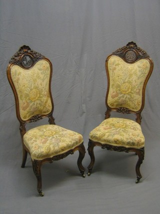 A handsome pair of Victorian high back walnut show frame chairs with carved cresting rails and pierced fret work decoration to the back, having upholstered seats and raised on French cabriole supports