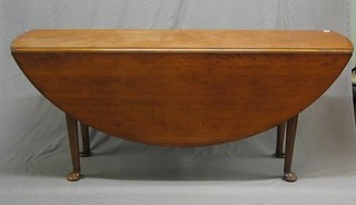 A 20th Century Georgian style mahogany oval drop flap Hunt table, raised on club supports 70"