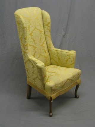A Queen Anne style armchair upholstered in yellow material, raised on cabriole supports
