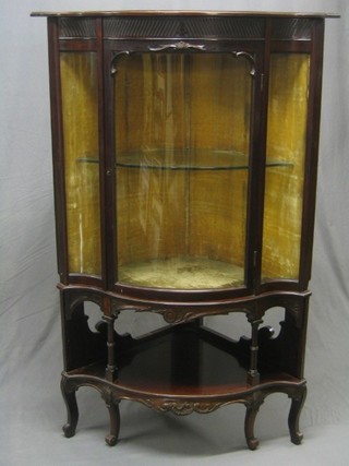 An Edwardian mahogany corner cabinet enclosed by glazed panelled doors, the base fitted a  niche, raised on cabriole supports 38"