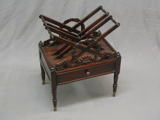 A Regency style Canterbury of X form with garland decoration, the base fitted a drawer and raised on turned supports 20"