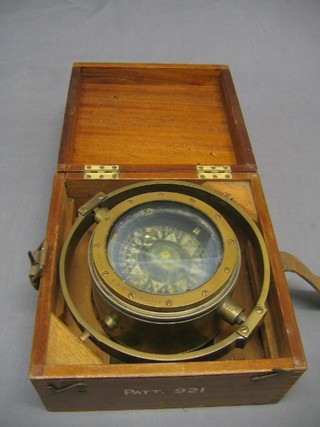 A brass ships compass contained in a binnacle marked patent 0921 E/R51 no. 6343H contained in a wooden carrying case