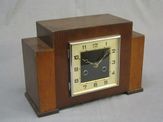 A 1930's Art Deco mantel clock with square silvered dial and Arabic numerals contained in an oak case
