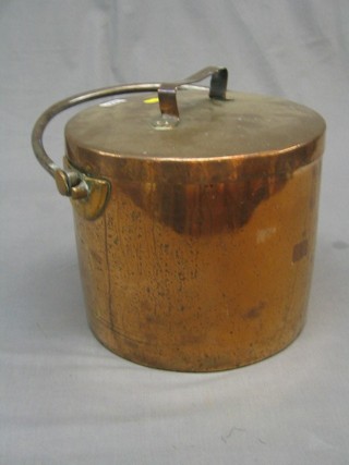 A circular copper coal bin and lid with polished steel swing handle
