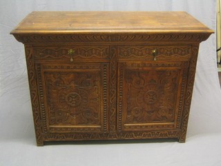 A 19th Century Continental carved oak cabinet fitted 2 drawers above a double cupboard, carved throughout, 55"