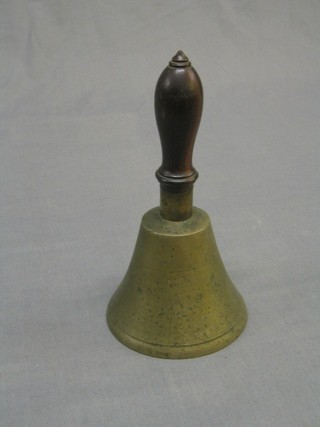 A brass hand bell with turned wooden handle