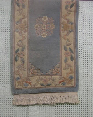 A blue ground Chinese slip rug with floral borders 49" x 26"
