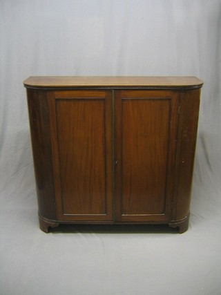 A 19th Century mahogany D shaped cabinet, the interior fitted shelves enclosed by panelled doors, raised on bracket feet 50"