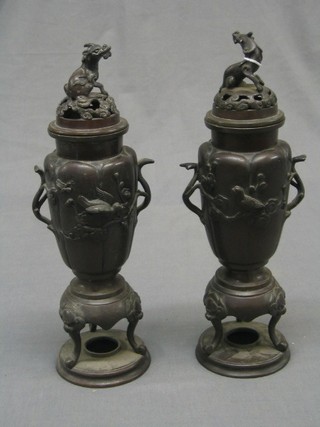 A pair of 19th Century bronze twin handled vases the pierced lids decorated seated dragons 13"