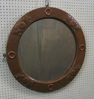 An Art Nouveau circular plate mirror contained in a hammered copper frame 24"