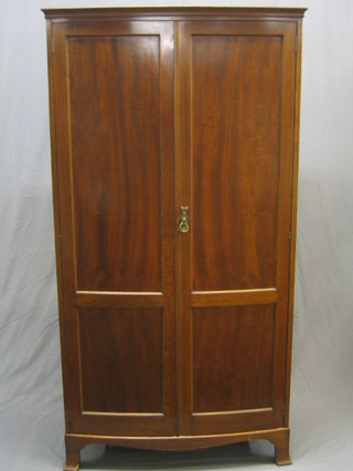 An Edwardian bow front mahogany wardrobe with moulded cornice, raised on bracket feet 37"