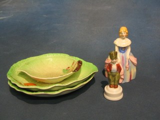 A 19th Century Continental porcelain figure of a standing Dutch boy 3", a 1930's pottery figure of a Crinoline lady 5" and 3 Carltonware leaf shaped dishes