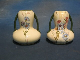A pair of Edwardian pottery twin handled vases decorated flowers, base marked H S London, 6"