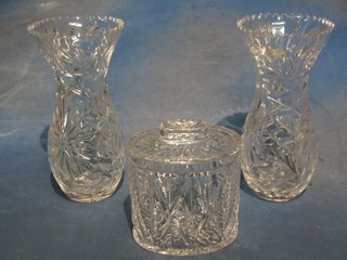 An oval cut glass biscuit barrel 5 1/2" and a pair of waisted cut glass vases 10" (2)
