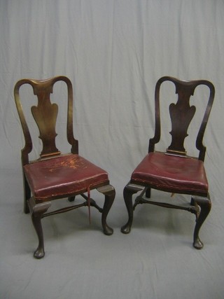 A pair of 19th Century Queen Anne style mahogany splat back dining chairs, the seats upholstered in red hide and raised on cabriole supports united by an H framed stretcher