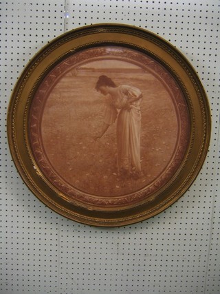 A 19th Century monochrome print of a standing girl picking flowers in a meadow, 20" circular and contained in a decorative gilt frame