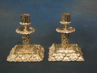 A handsome pair of Rococo style pierced silver plated stub candlesticks, raised on square feet 5"