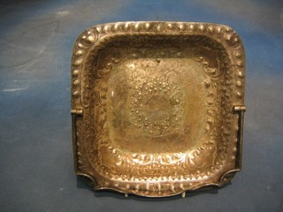 A square embossed silver plated cake basket with swing handle, raised on bracket feet